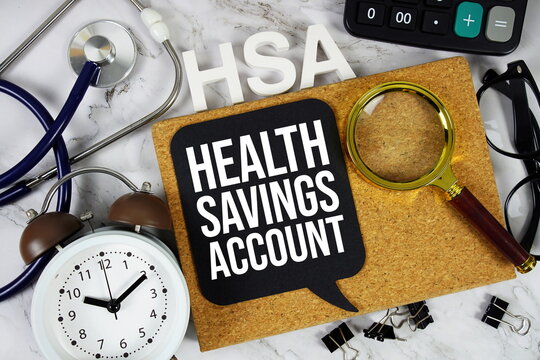 HSA - Health Savings Account acronym with alarm stethoscope, alarm clock and magnifying glass, medical and healthcare concept background