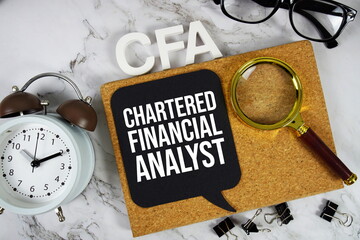 CFA - Chartered Financial Analyst acronym with alarm clock and magnifying glass, Business concept...