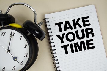 Take Your Time text written on notepad with alarm clock