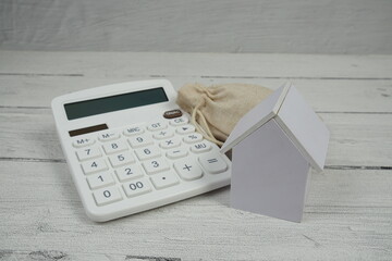 House Model and Caculator on wooden background