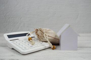 House Model and Caculator on wooden background