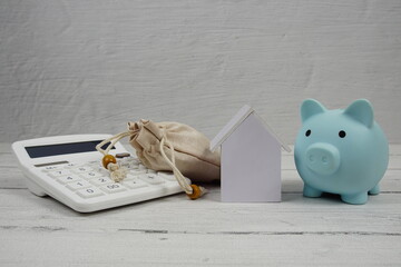 House Model with Caculator and Piggy bank on wooden background
