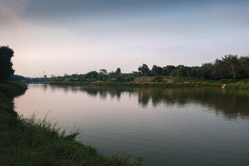 Peaceful Riverbank Scene With Calm Water and Greenery in Natural Setting