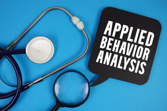 Applied Behavior Analysis text with Stethoscope and magnifying glass on blue background