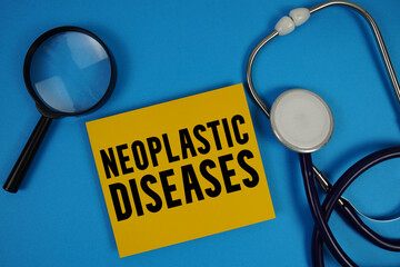 Neoplastic Diseases  text with Stethoscope and magnifying glass on blue background
