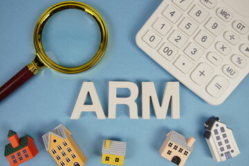 ARM abbreviation of Adjustable Rate Mortgage alphabet letters with house model, magnifying glass...