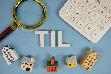 TIL abbreviation of Truth in Lending alphabet letters with house model, magnifying glass and...