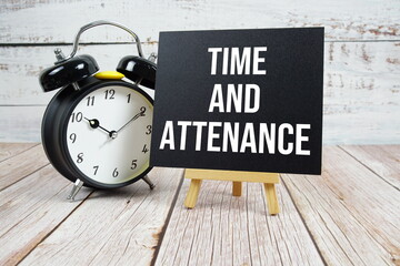 Time and Attendance text with easel and alarm clock on wooden background