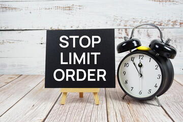 Stop Limit Order text with easel and alarm clock on wooden background