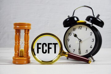 FCFT abbreviation of Fixed Cost, Fixed Time text with alarm clock on wooden background