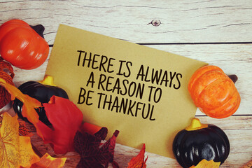 There Is Always A Reason To Be Thankful text with element decorations on wooden background