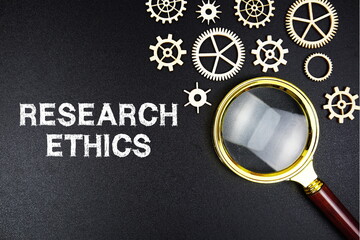 Research Ethics text message with magnifying glass on black background