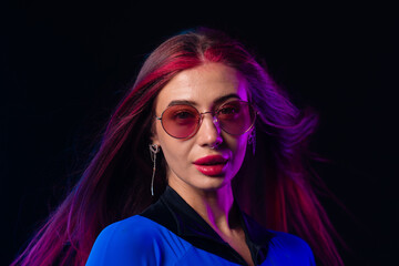 Stylish futuristic woman in blue bodysuit and sunglasses