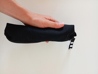 hand holding a black minimalist pencil case on a white background