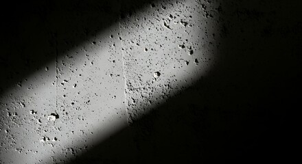 Strong diagonal ray of light illuminating rugged distressed gray concrete wall textured background close-up industrial urban grunge surface pattern detail backdrop abstract