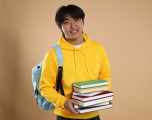 Student with books and backpack on beige background
