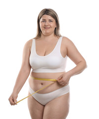 Weight loss. Plus size woman measuring waist with tape on white background