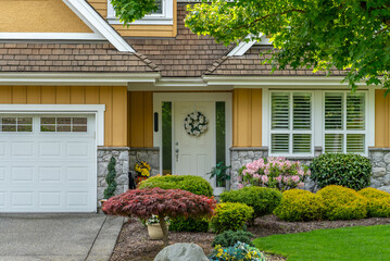 Establishing shot. Two story stucco luxury house with nice spring blossom landscape in Vancouver,...
