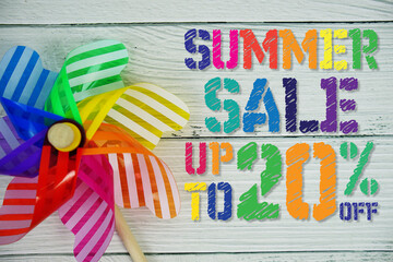 Summer Sale 20% off text with Colorful Windmill on wooden background