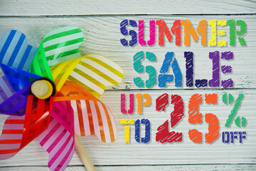 Summer Sale 25% off text with Colorful Windmill on wooden background
