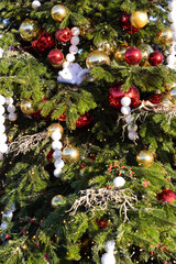 Decorated Christmas tree with Christmas balls, tinsel and warm yellow lights. Festive atmosphere.