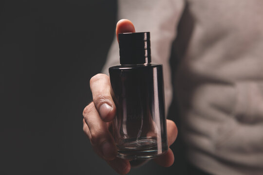 men 's hands with bottle of perfume