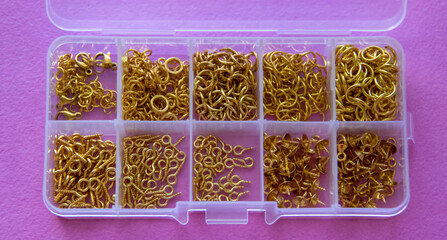 Furniture, beads for diy A clear container filled with shiny gold beads, ideal for holiday crafts...