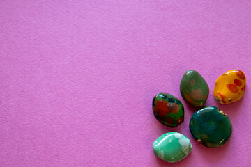 Furniture, beads for diy A collection of colorful gemstones rests on a sparkling pink background.