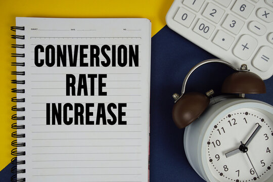 Conversion Rate Increase text written on notepad with calculator and alarm clock on navy blue background
