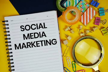 Social Media Marketing text with magnifying glass and stationery on yellow background