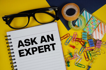Ask an Expert text with eyeglasses and stationery on yellow background