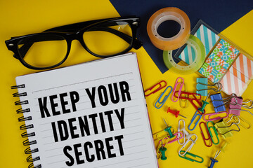 Keep Your Identity Secret text with eyeglasses and stationery on yellow background