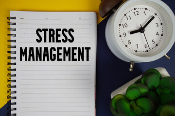 Stress Management text written on notepad with alarm clock on blue background