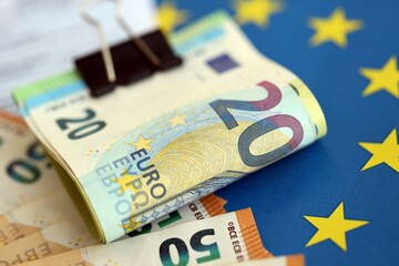 European euro currency money notes bunch on tax form and European union blue flag close up