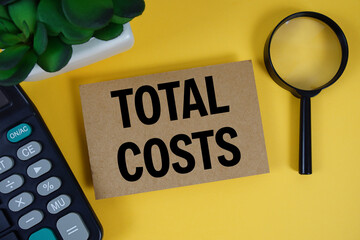 Total Costs text with magnifying glass anc calculator on yellow background