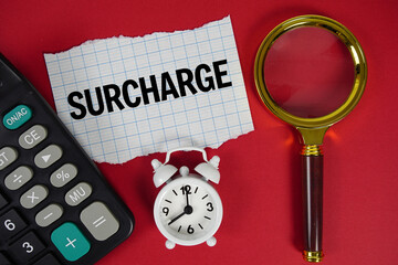 Surcharge text with alarm clock, magnifying glass anc calculator on red background