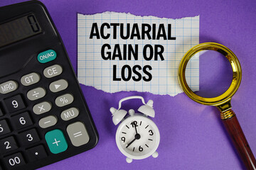 Actuarial Gain or Loss text with alarm clock, magnifying glass anc calculator on purple background