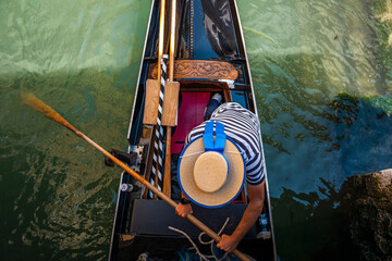 Gondolier with hat in gondola in Venice