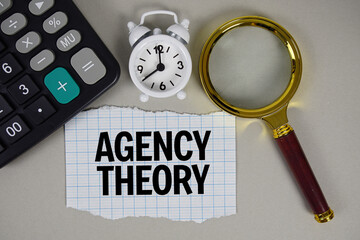 Agency Theory text with alarm clock, magnifying glass anc calculator on gray background