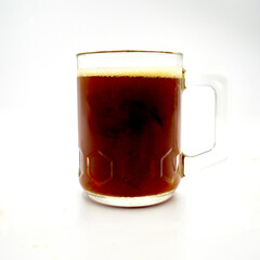 A dark ale in a glass isolated against a white background.