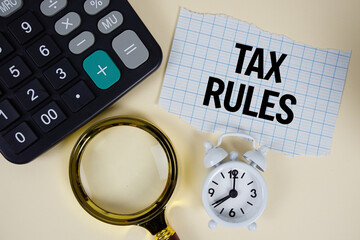 Naklejka na ściany i meble Tax Rules text with alarm clock, magnifying glass anc calculator on yellow background