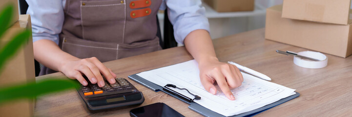 Asian Adult Woman Calculating Business Finances for Online Store Small Business Accounting and...