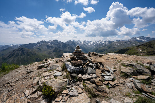 rock cairn or stone cairn on top of Versettla in Gaschurn Montafon Vorarlberg Austria with view towards the snow covered peaks of the silvretta group