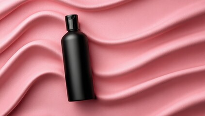 Matte black bottle on pink satin