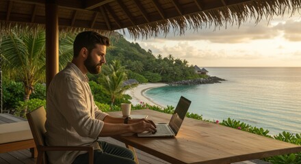 Man Working on Laptop at Beachside Hut During Sunset in Tropical Paradise