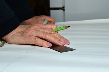 The moment when a cutter creates patterns for sewing clothes. The clothes designer applies markings...