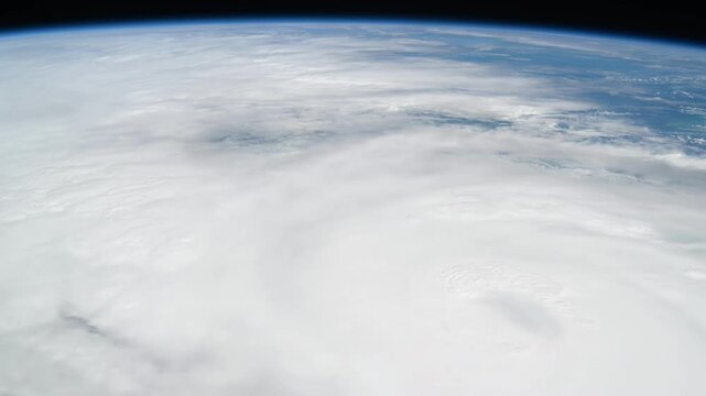 Powerful Tornado Over Florida - Storm View from Space. Source material was provided by NASA. Aerial view of a massive tornado vortex over Florida's blue ocean during a severe storm. The swirling funne