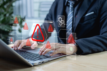 Cybersecurity and virus protection concept, hand on laptop with holographic red alert icons, system warning signals, digital threats, data breaches, and IT risk management.