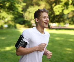 Sporty man with armband running in park