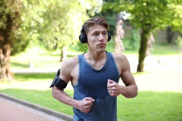 Sporty man with headphones running in park